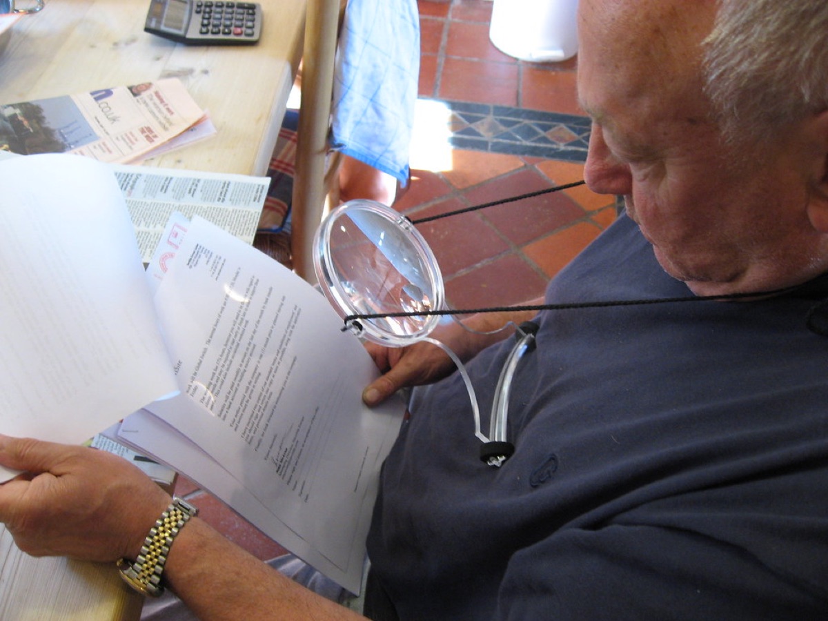 A magnifying glass held over a document to inspect fine print details.
