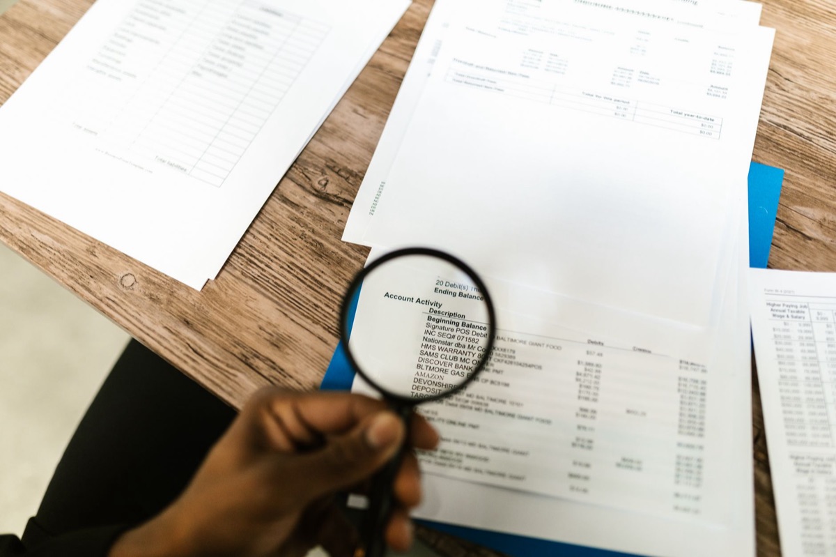 Une loupe examinant attentivement un contrat d'assurance papier.