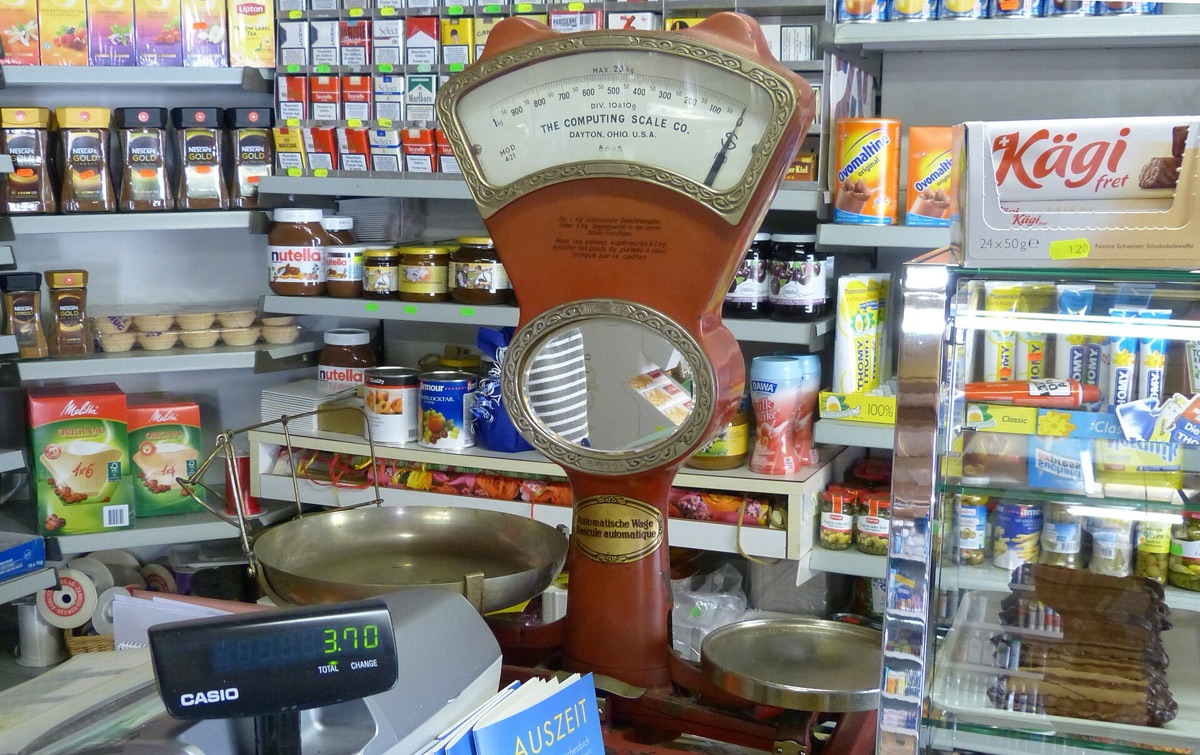 Une balance de bureau équilibrant des poids pour illustrer le calcul des frais.