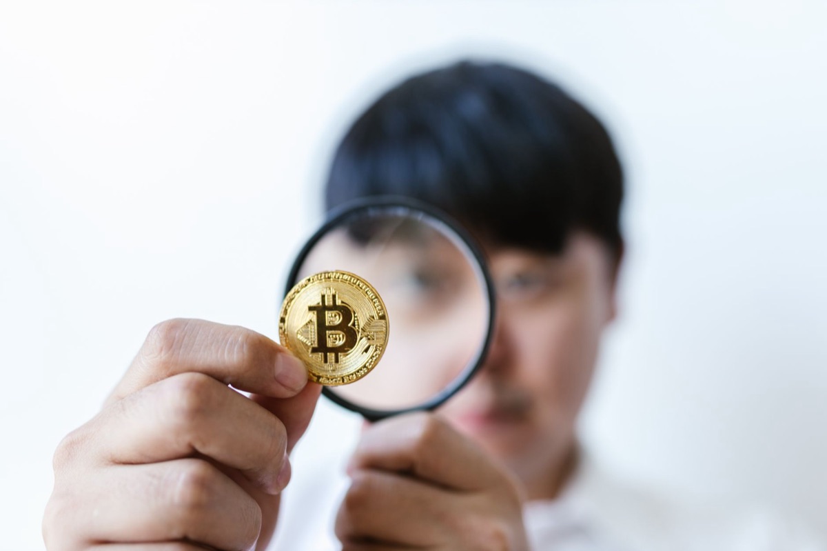 Moedas empilhadas com uma lupa para representar o cálculo do valor do prêmio.
