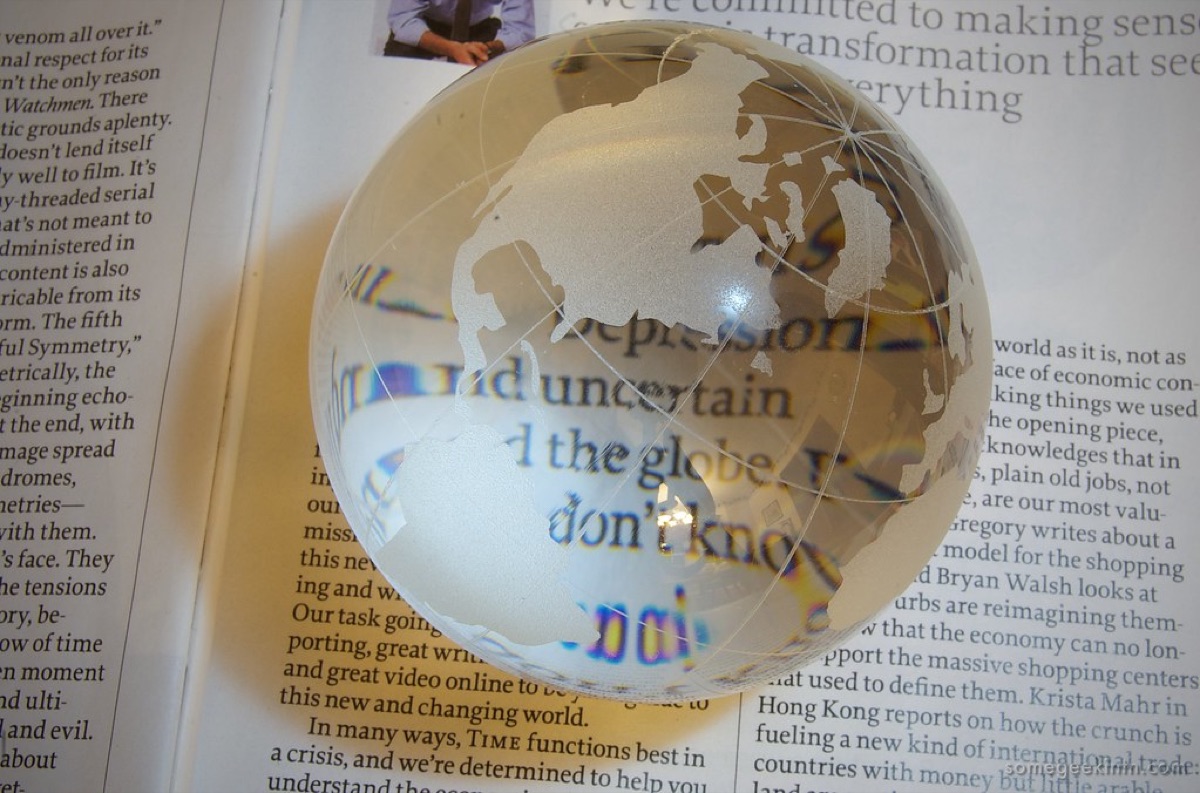A magnifying glass held over a printed financial document to inspect fine print.