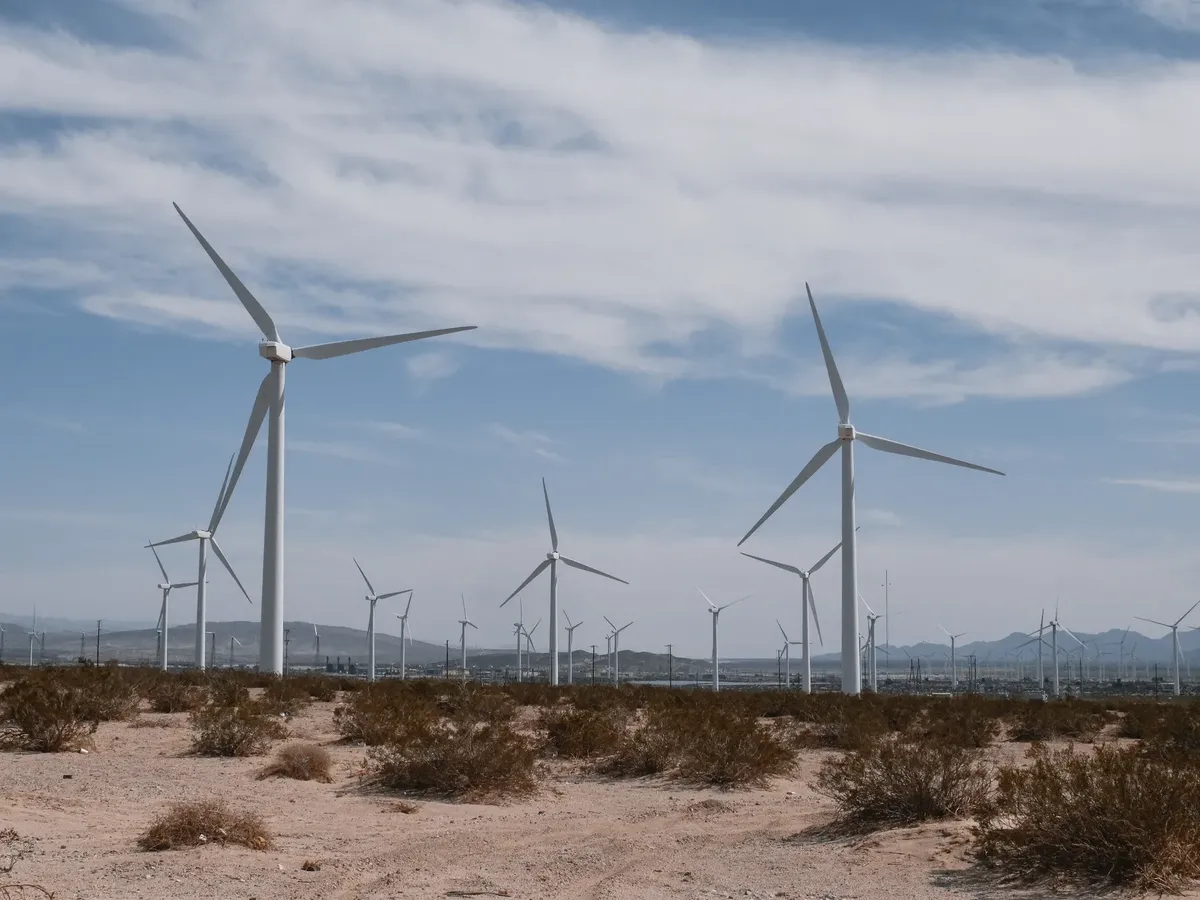 砂漠に広がる風力発電タービンの風景。これは清潔で再生可能なエネルギー技術を象徴しています。